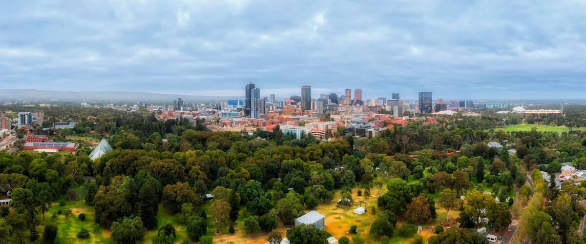 A cityscape with a mix of modern skyscrapers and green spaces.