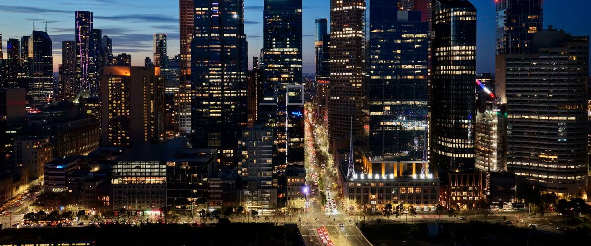 Melbourne, Victoria, Australia by night– 4K aerial drone view of Melbourne CBD skyline, Yarra River, and illuminated skyscrapers at sunset twilight