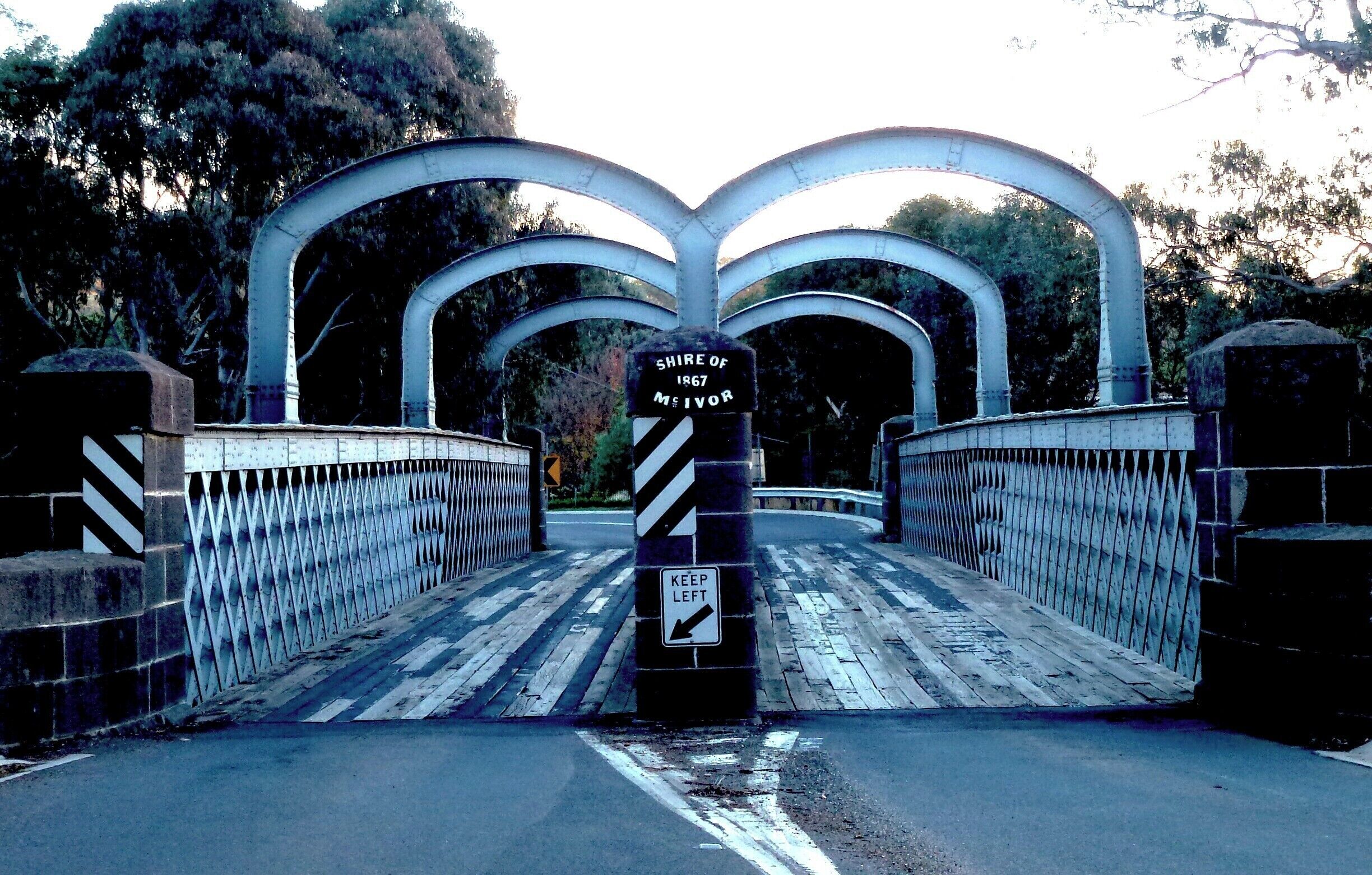 A metal bridge with a 'Keep Left' sign and a 'Shire of 1867 Meivor' sign.