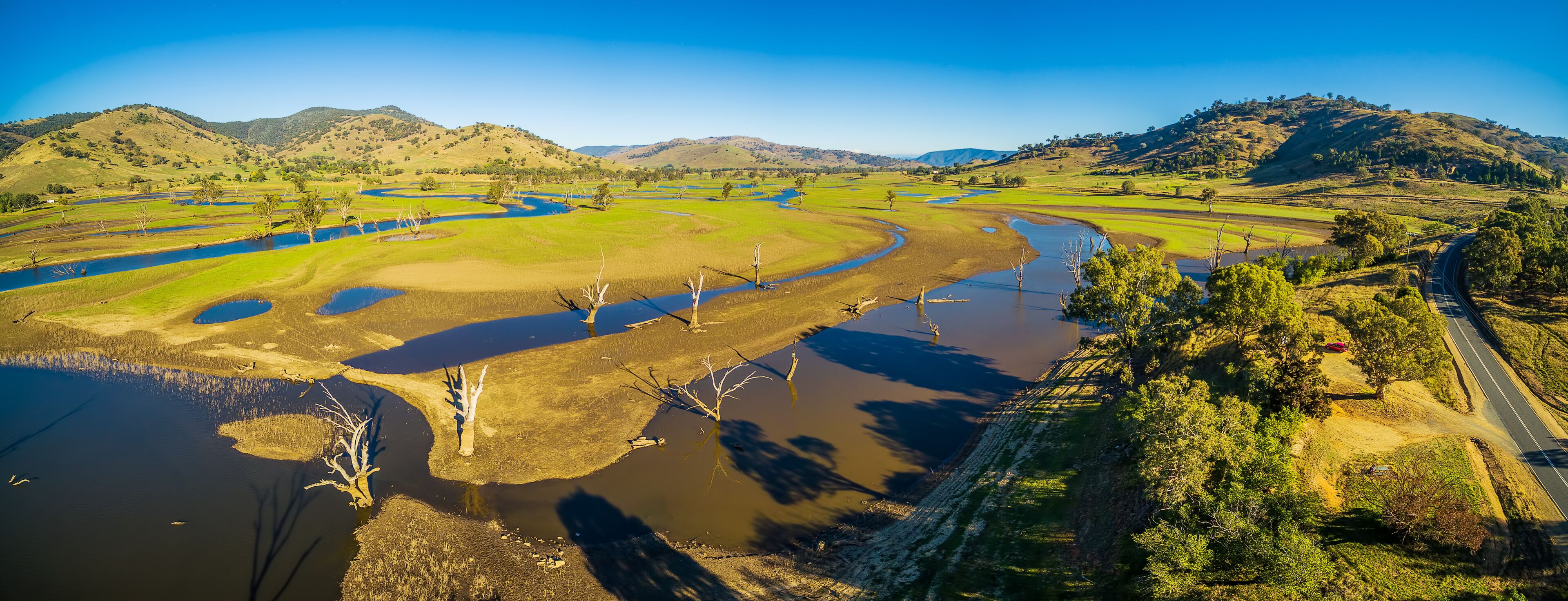 A river winding through a valley with hills in the background.
