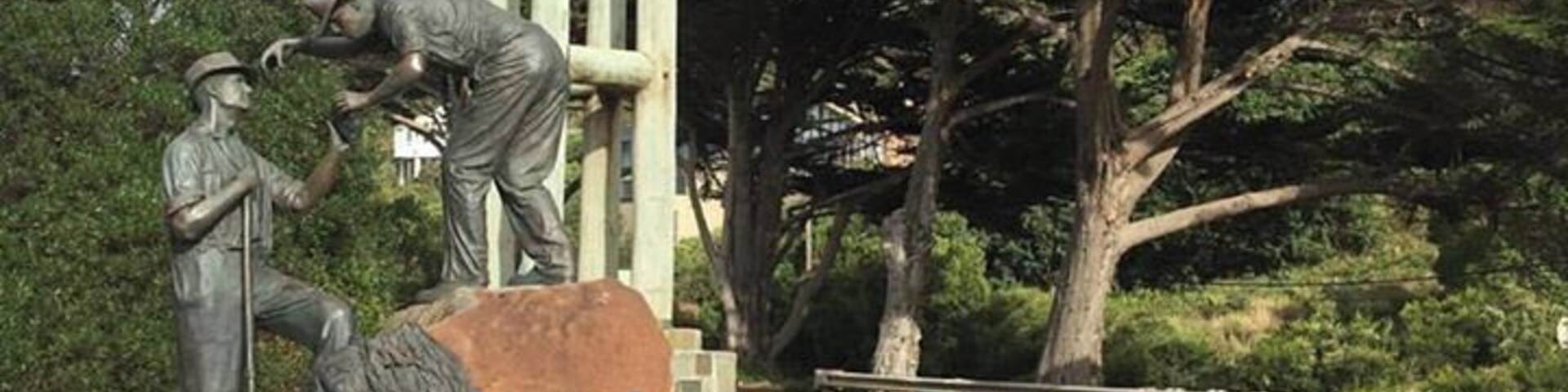 A statue of a man and woman, a wooden structure, and a road sign reading "Great Ocean Road".