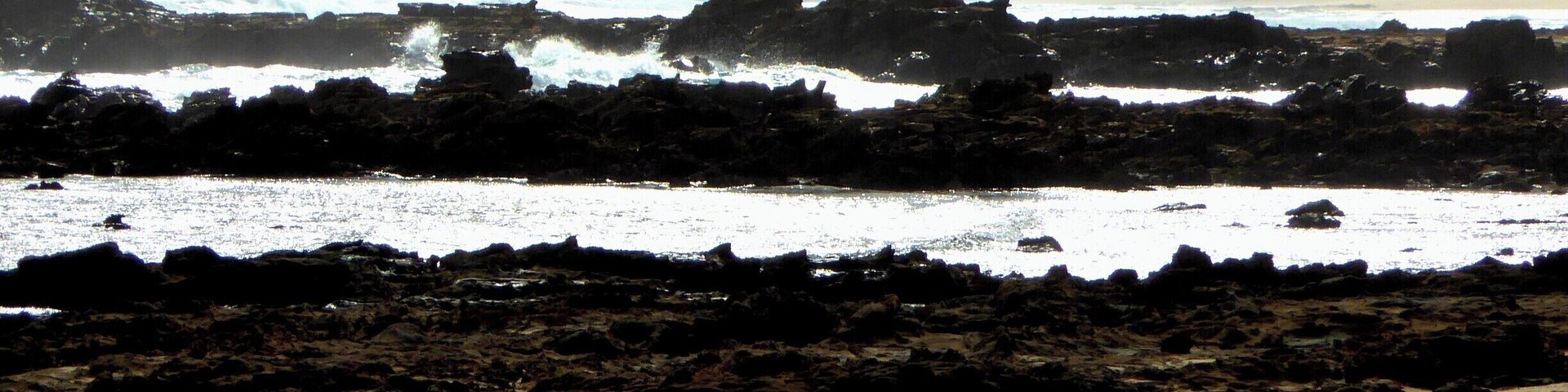 Una playa rocosa con olas rompiendo en la orilla.