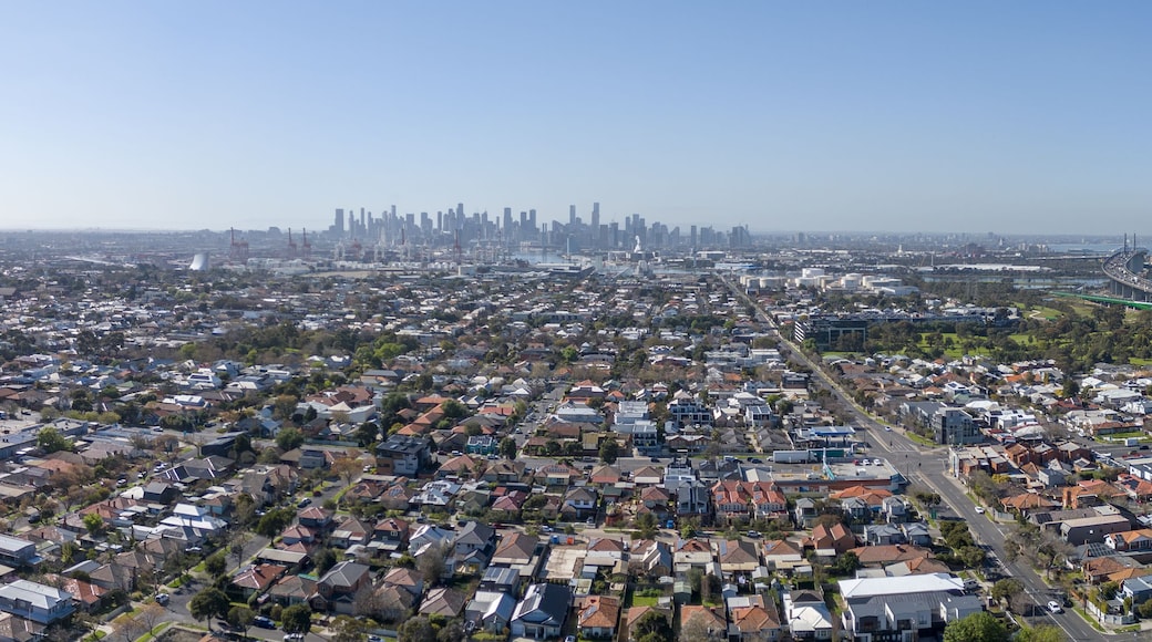 A densely populated urban area with a prominent industrial building and a distant city skyline.
