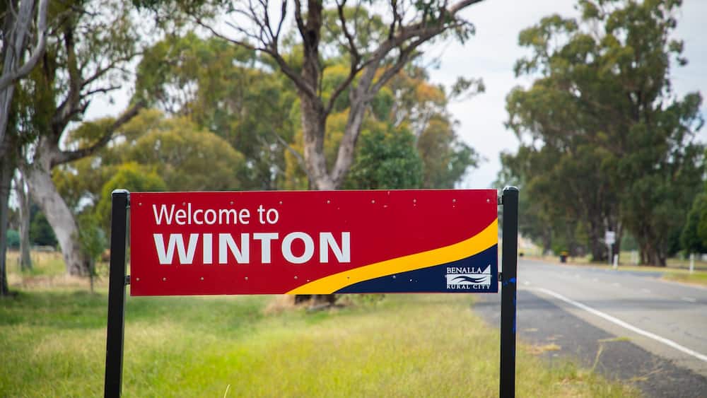 A welcome sign for Winton, Benalla Rural City, with a road and trees in the background.