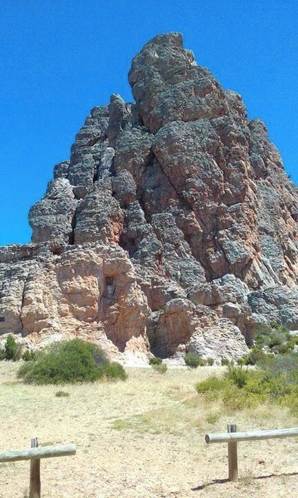 A large rock formation with a clear blue sky in the background.
