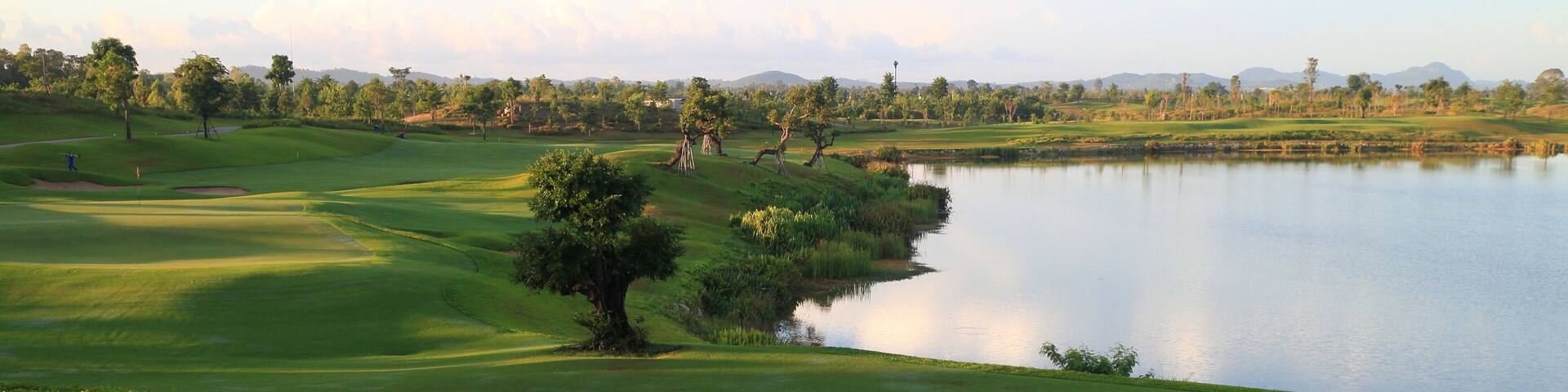 Golf course, lake, sky and green grass,Tropical golf course at sunset, Thailand