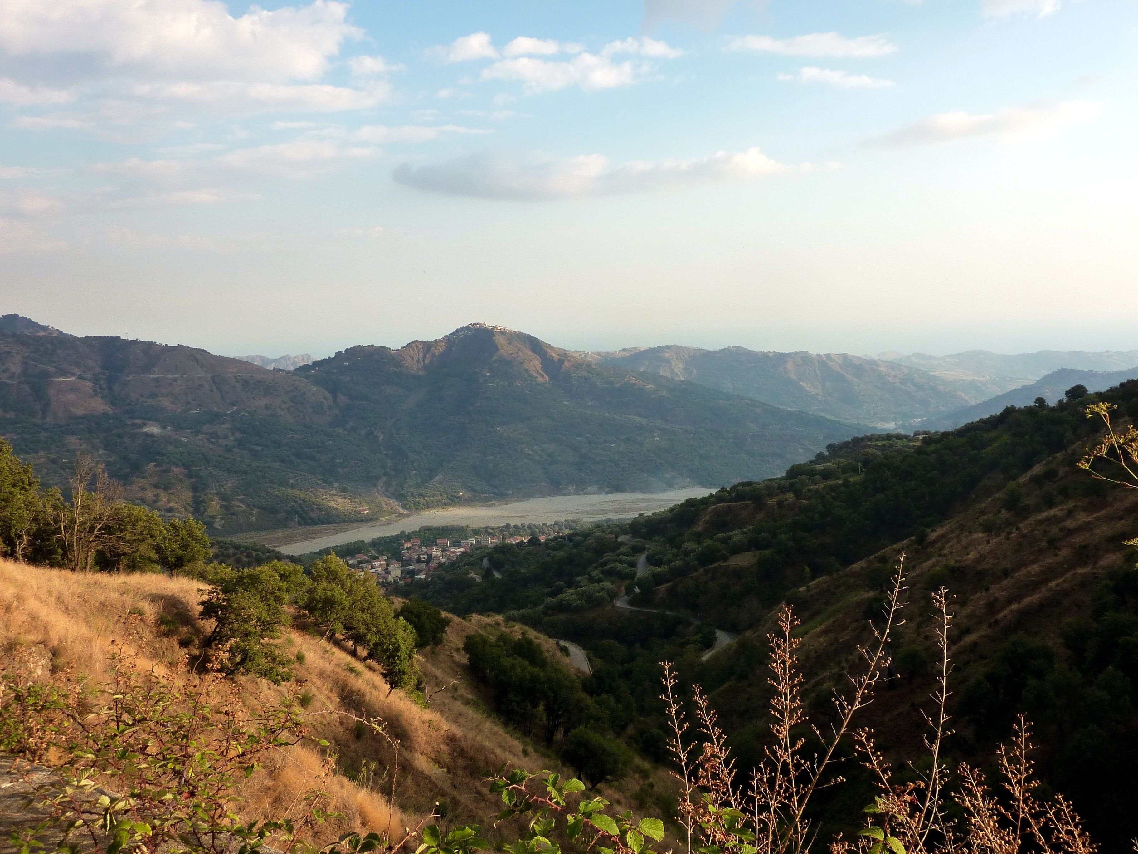 A mountainous landscape with a river valley and a town in the distance.