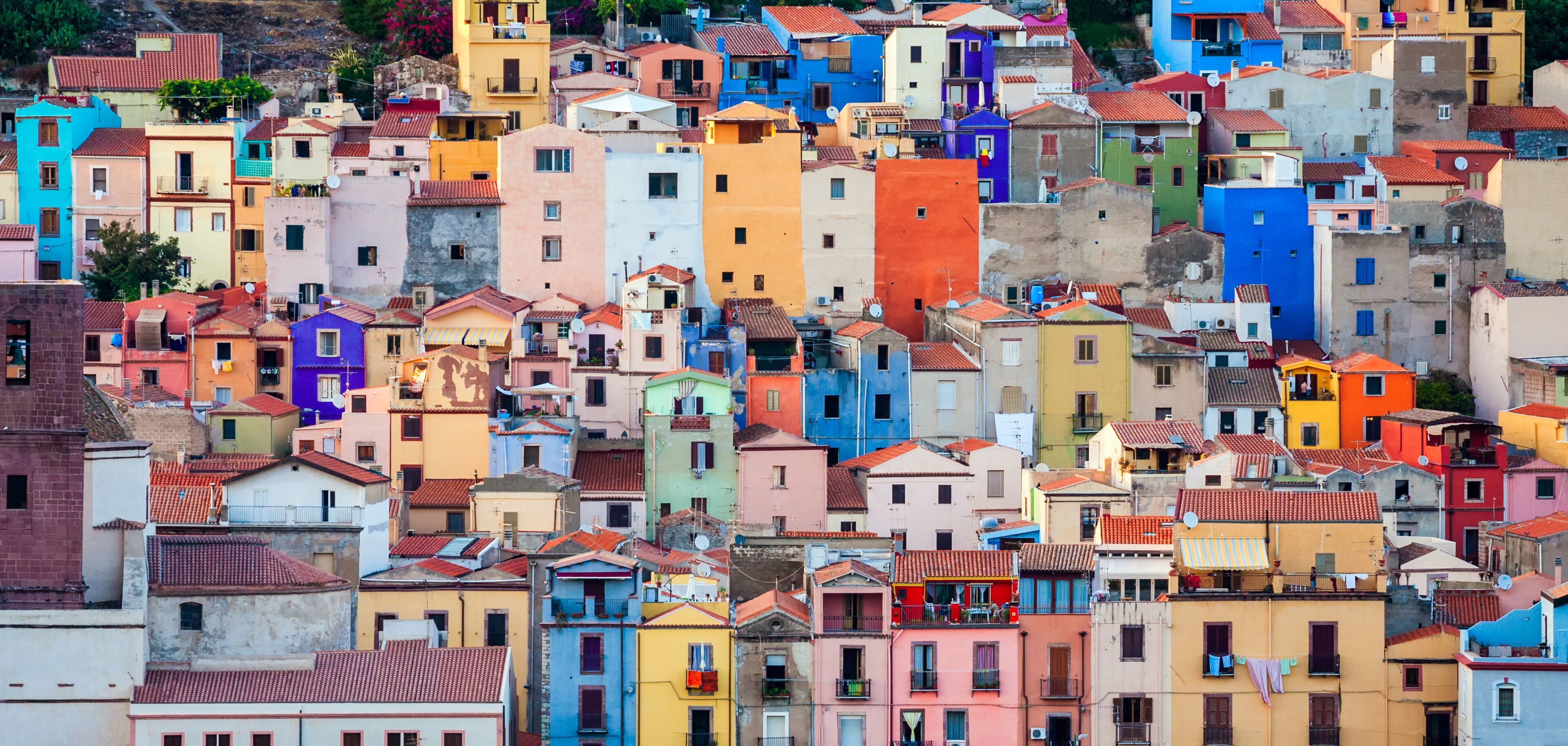 A densely packed urban area with colorful buildings and red-tiled roofs.