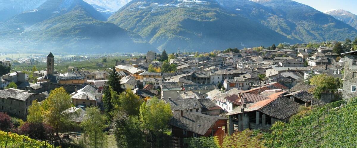 A mountainous village with vineyards and traditional stone buildings.