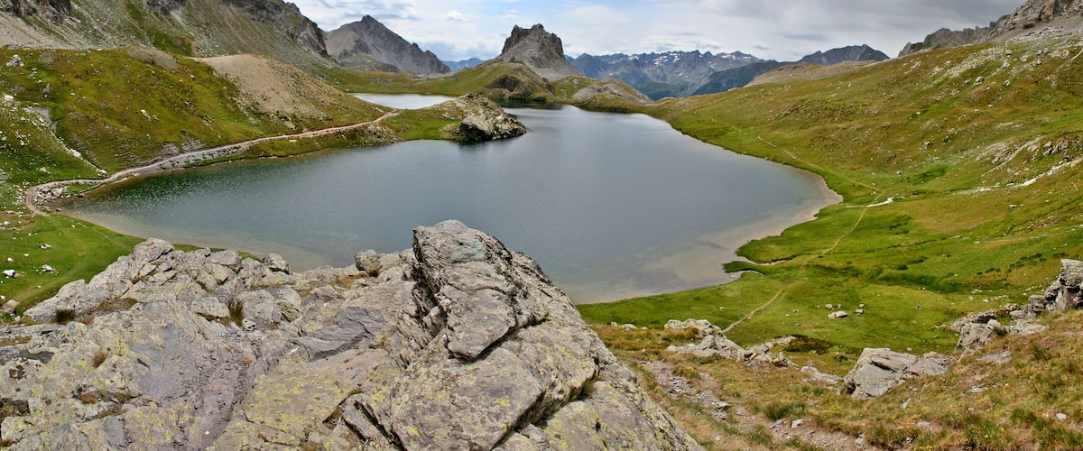 A mountain lake surrounded by rocky terrain and distant peaks.