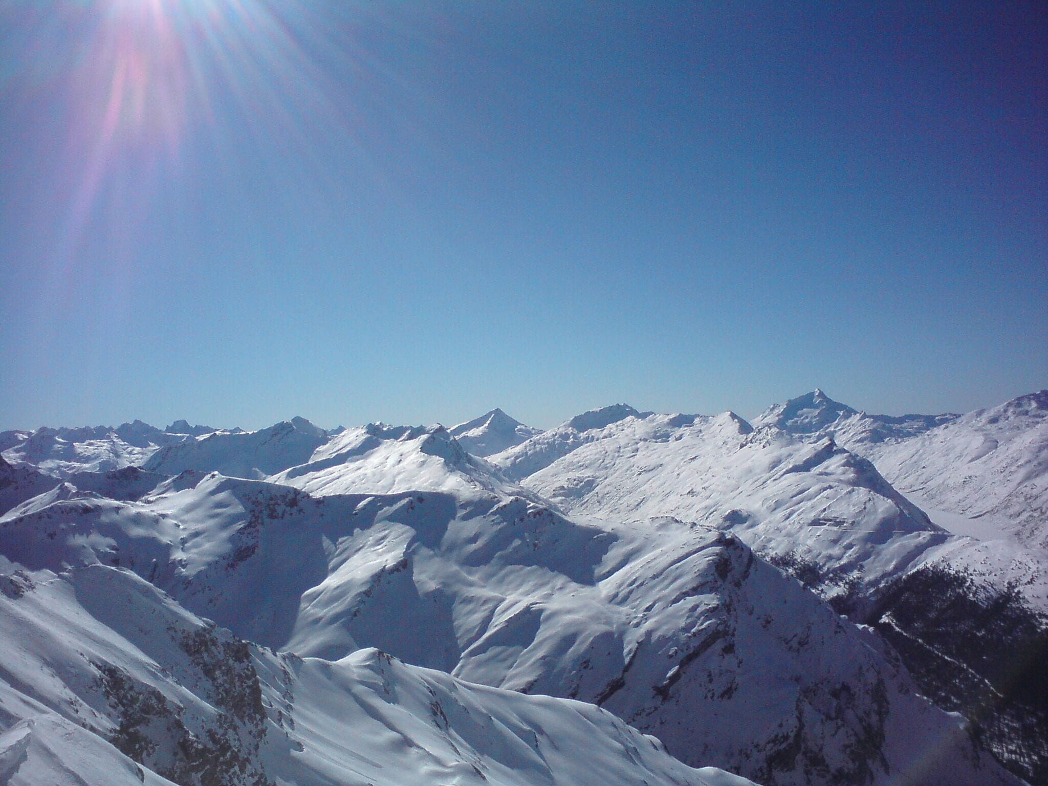 A snow-covered mountain range under a clear blue sky.