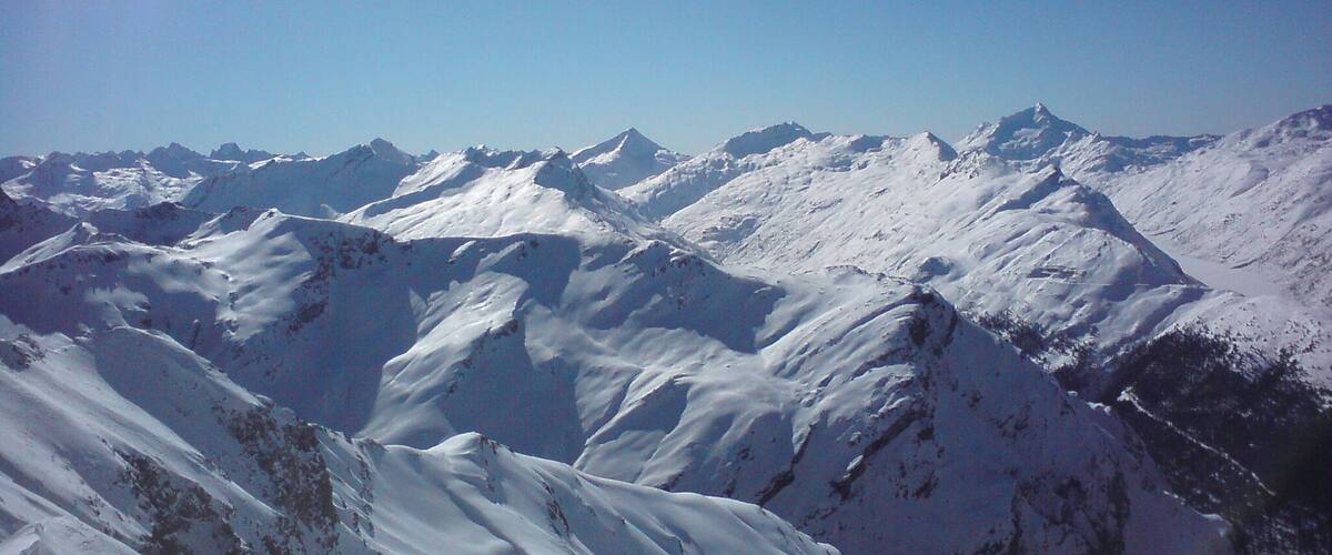A snow-covered mountain range under a clear blue sky.