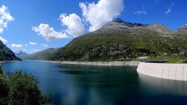 A mountain lake with a dam and a clear sky.