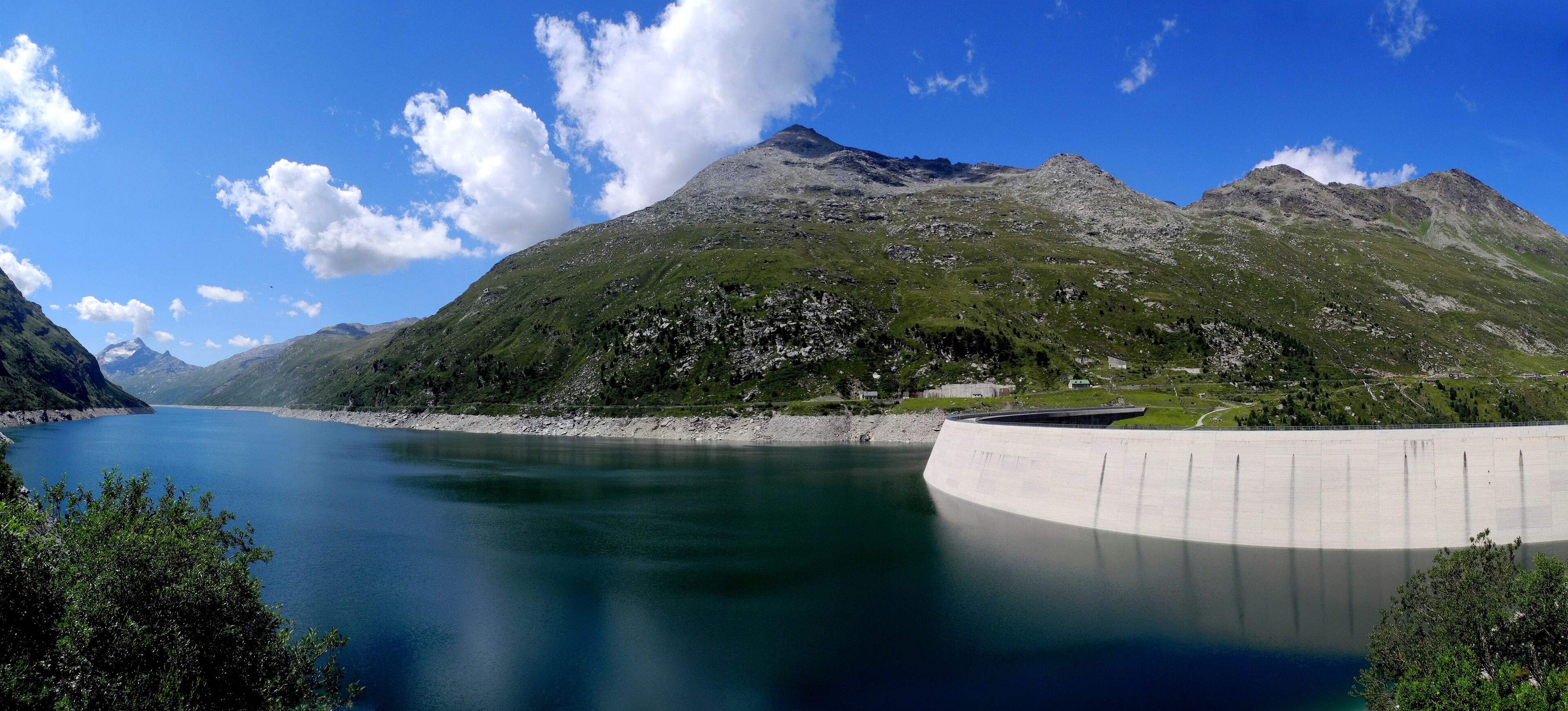 A mountain lake with a dam and a clear sky.