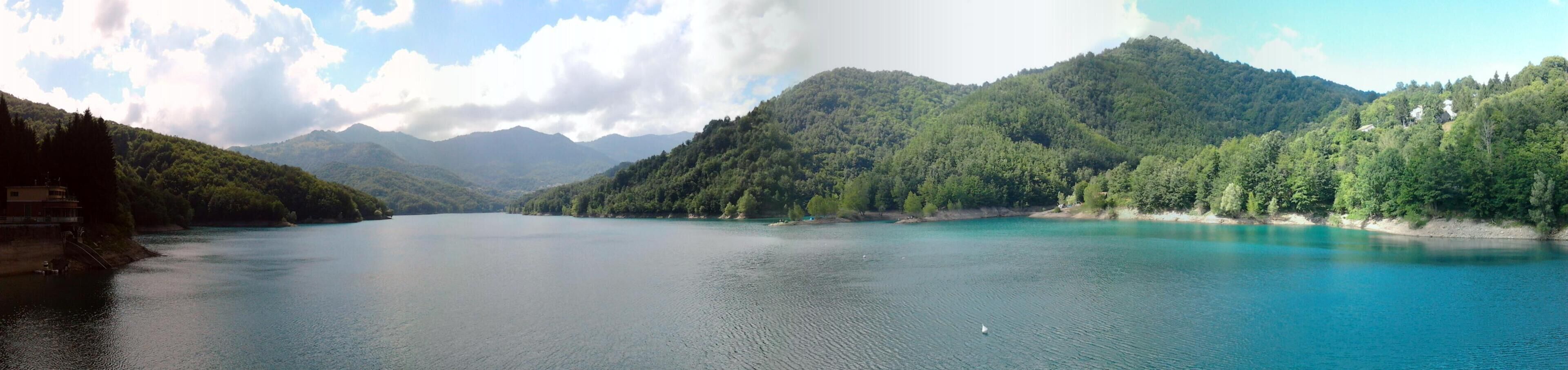 A calm lake surrounded by forested mountains.