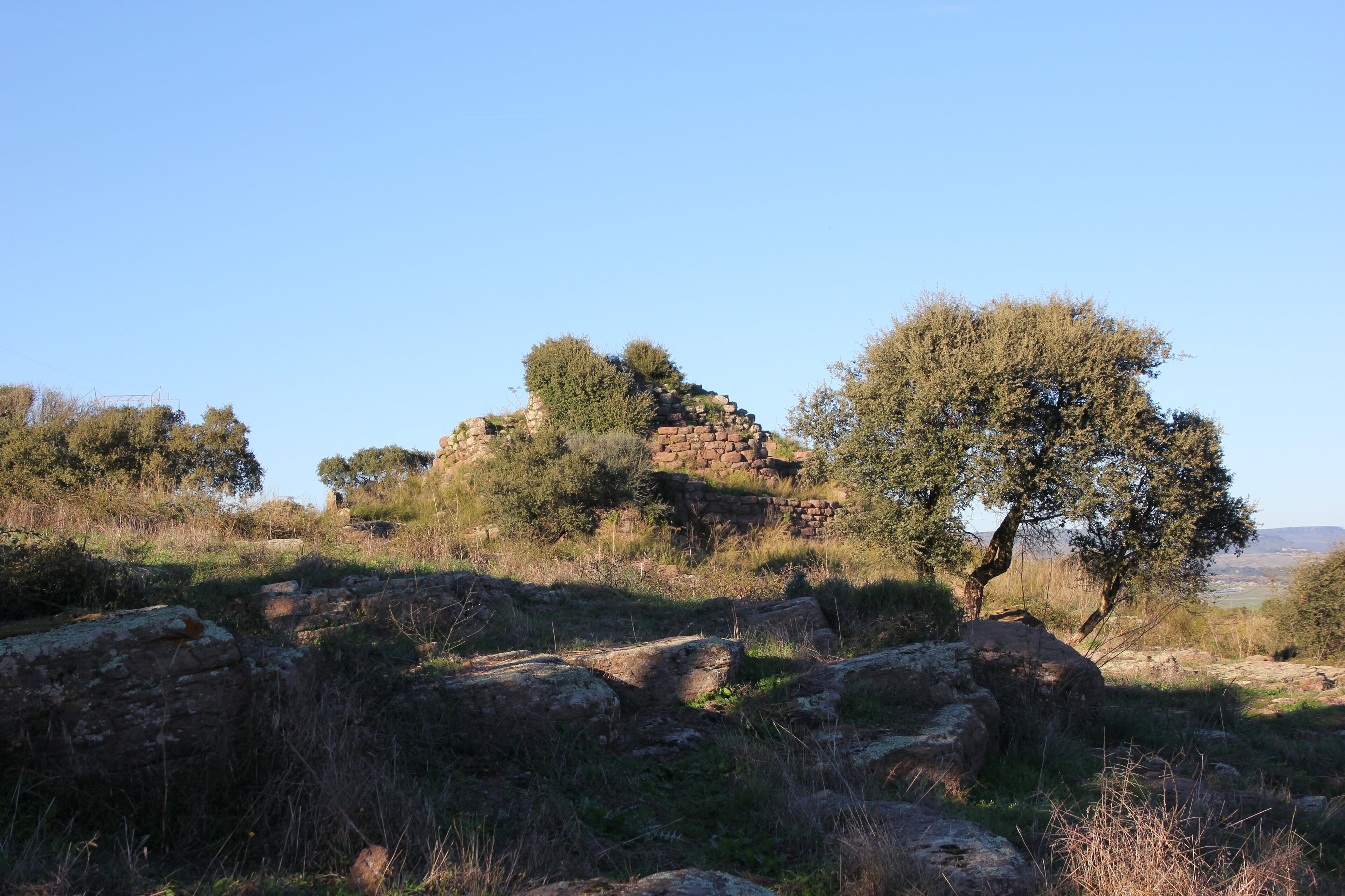 A rocky landscape with a stone structure and trees.