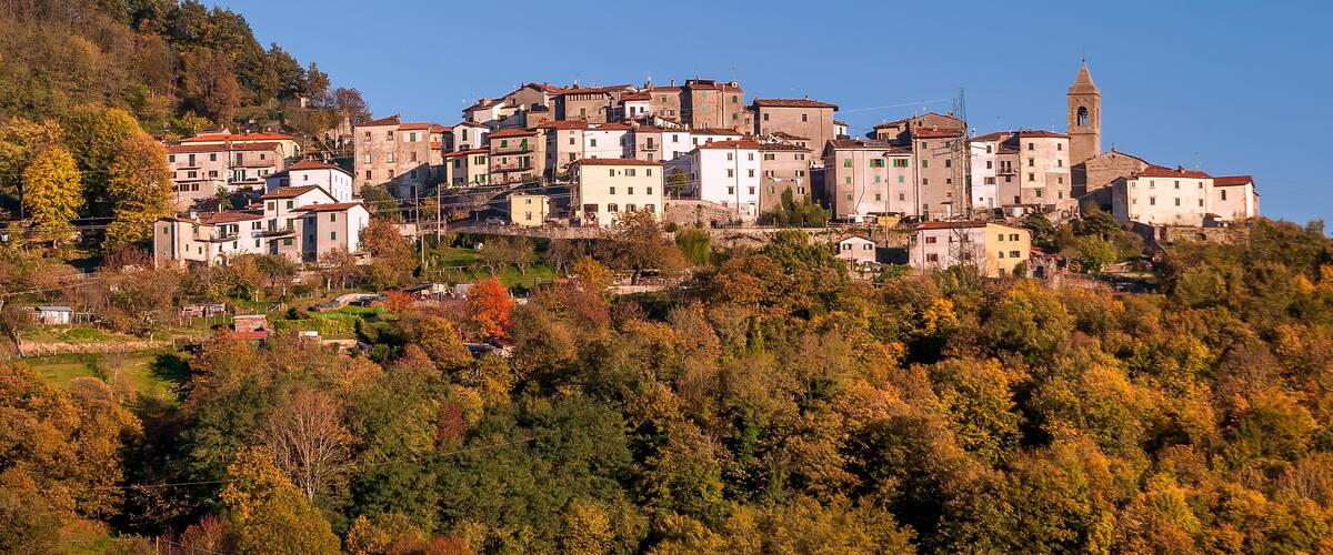 A hillside town with historic buildings and a church tower.