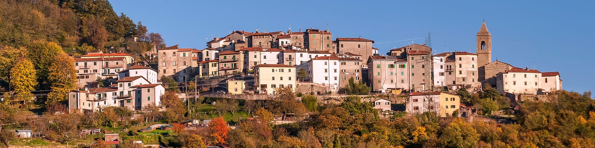 A hillside town with historic buildings and a church tower.