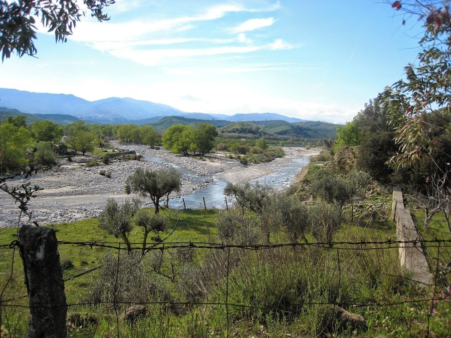 A river flowing through a valley with mountains in the background.