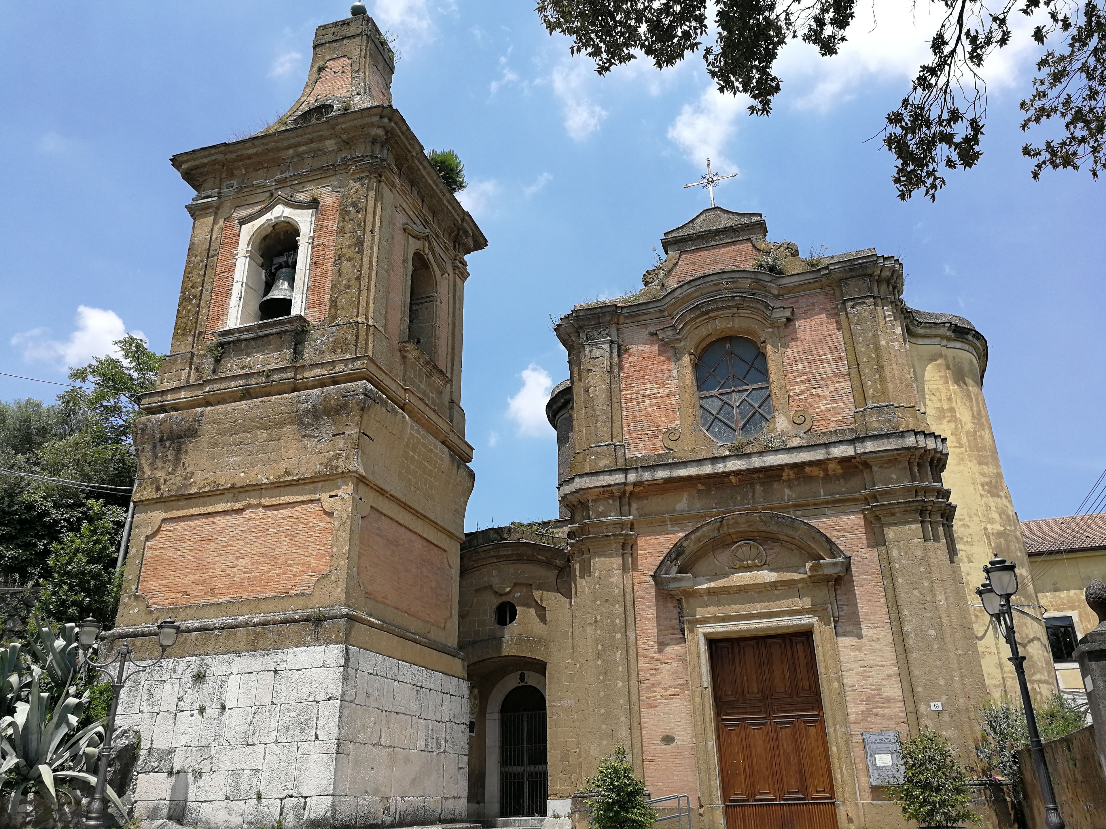 A historic church with a bell tower and a smaller adjacent structure, both featuring classic architectural details.