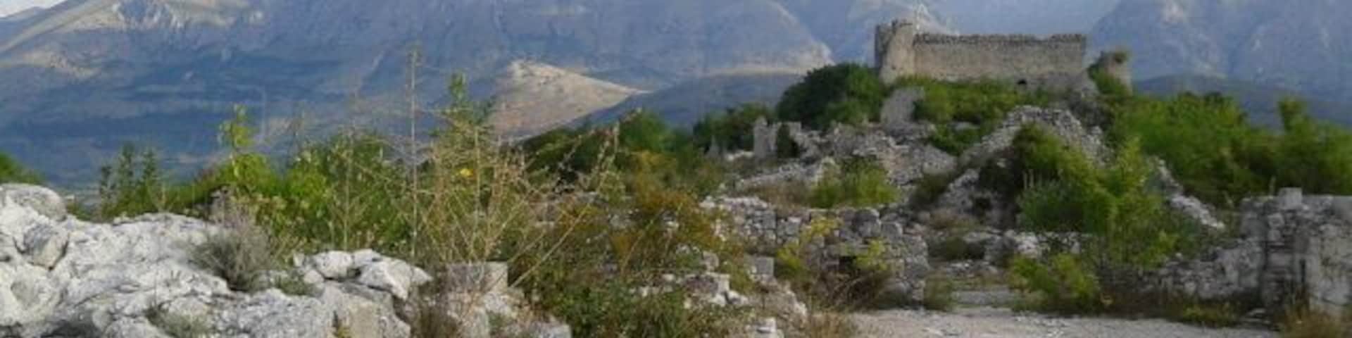 Un paisaje montañoso con ruinas y cielo despejado.
