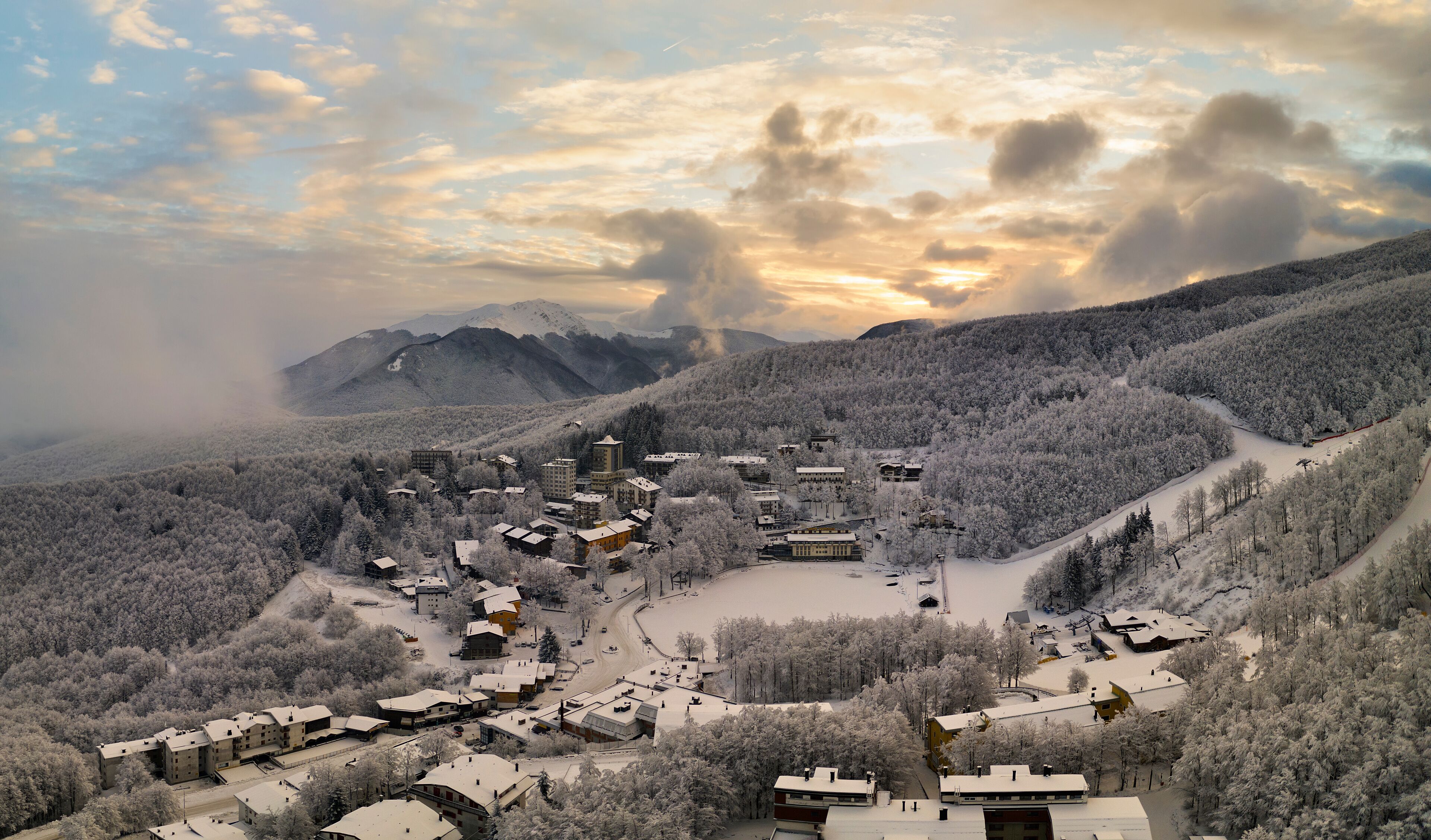 Panoramic aerial view of Cerreto Laghi town in winter season at sunrise, municipality of Ventasso, Reggio Emilia province, Emilia Romagna, Italy, Europe