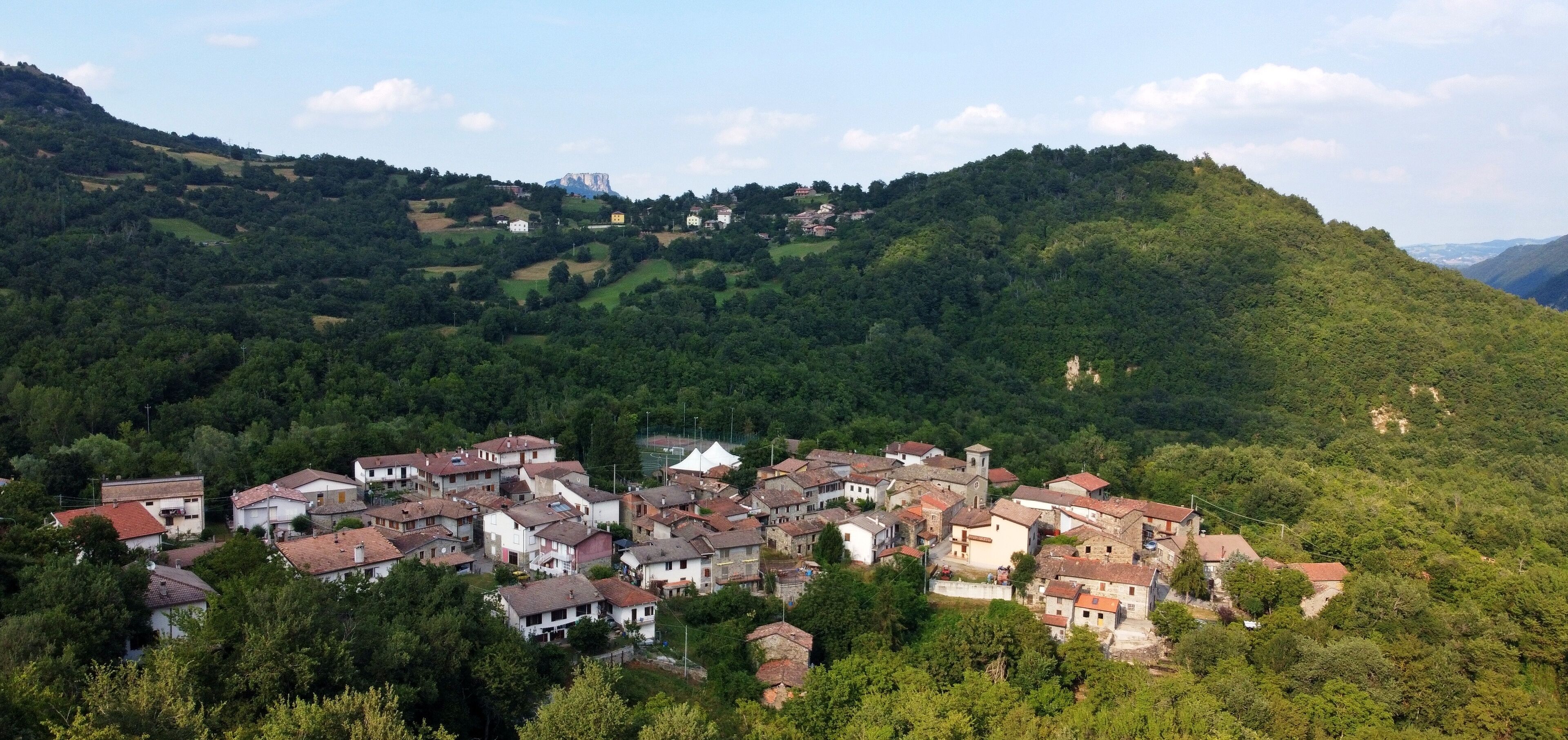 Aerial view of the village of Talada with the Bismantova stone in the background. Cervarezza, Ventasso, Reggio Emilia, Italy