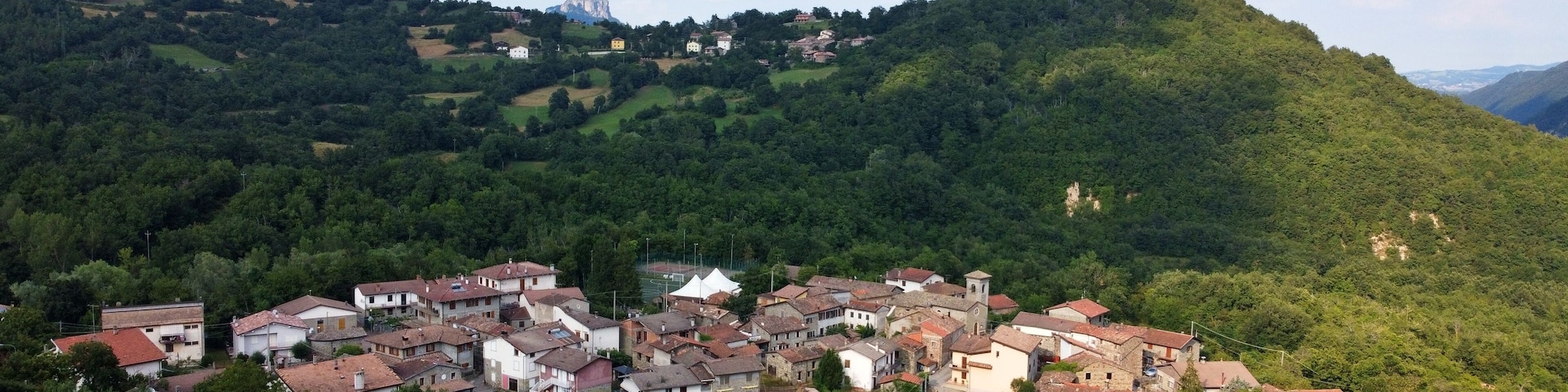 Aerial view of the village of Talada with the Bismantova stone in the background. Cervarezza, Ventasso, Reggio Emilia, Italy