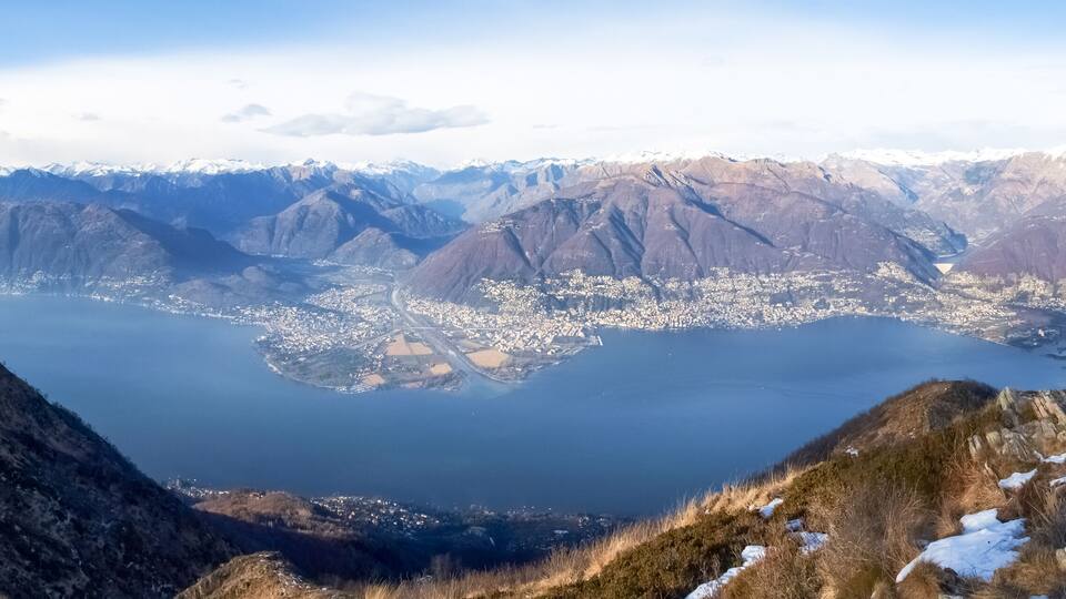 A mountainous landscape with a large lake surrounded by snow-capped peaks.