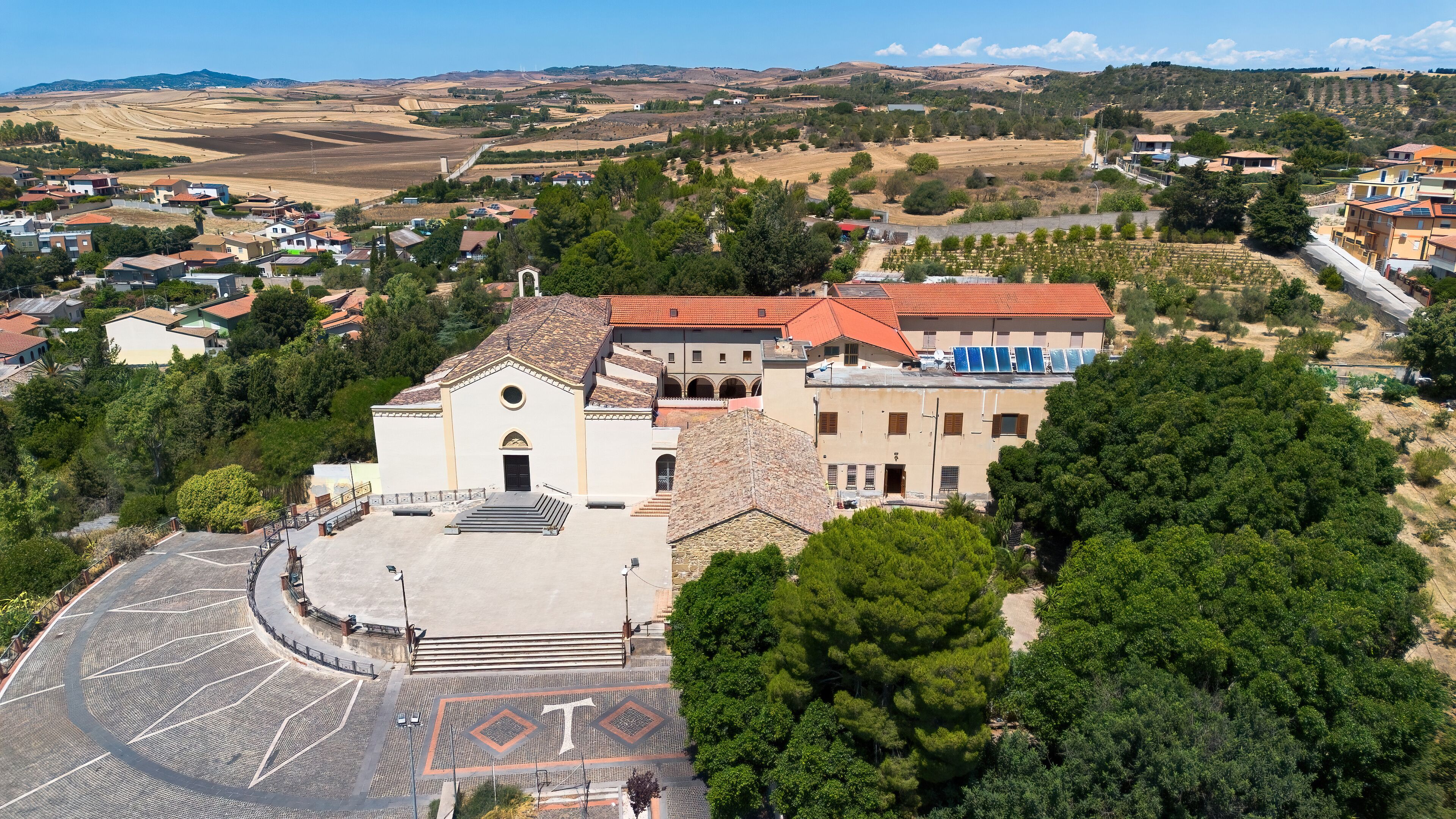 A church with a tiled roof and a courtyard with a geometric pattern.
