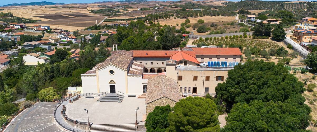 A church with a tiled roof and a courtyard with a geometric pattern.