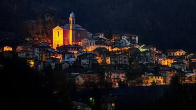 A village at dusk with a prominent church and residential buildings.