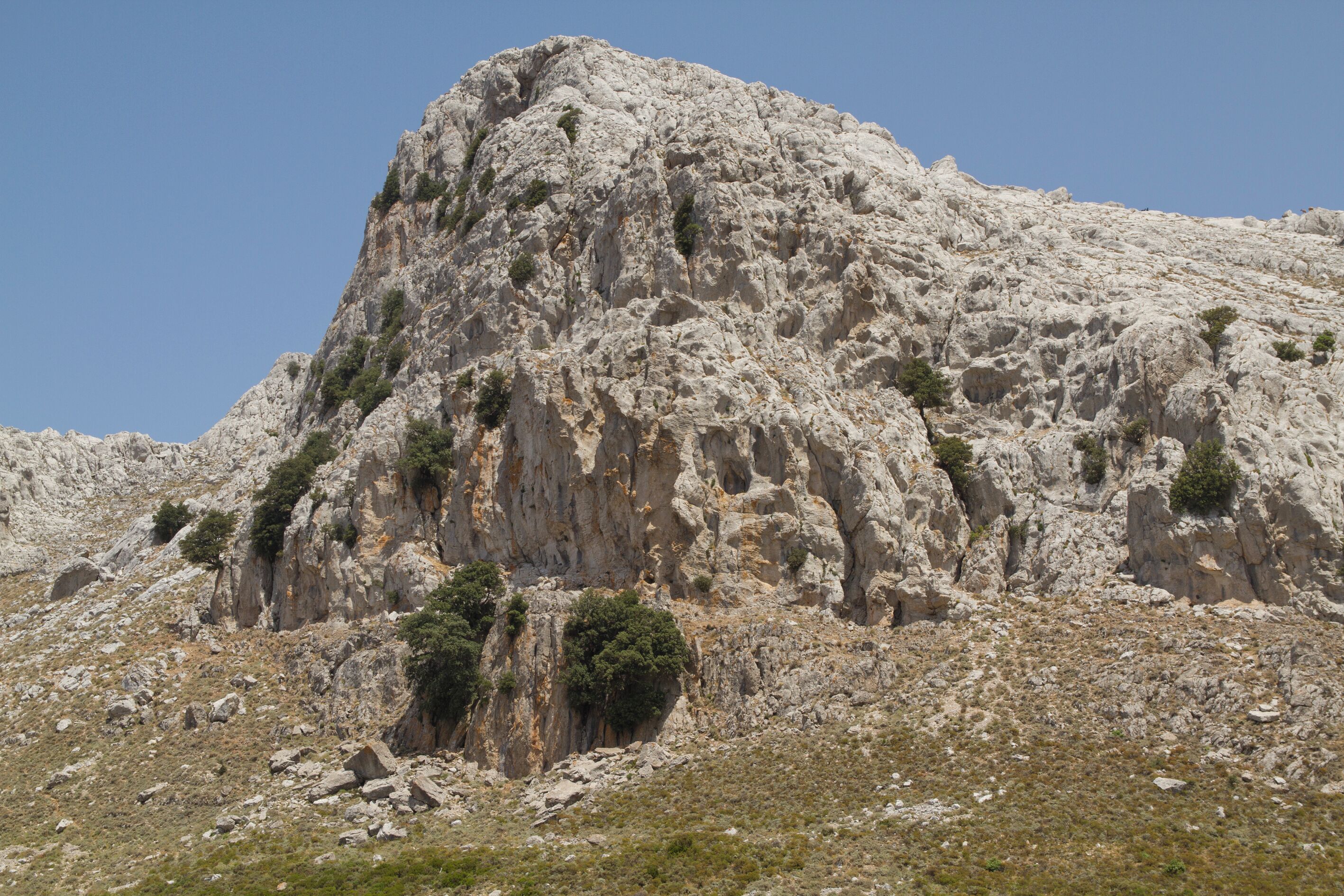 A rugged mountain with rocky terrain and sparse vegetation.