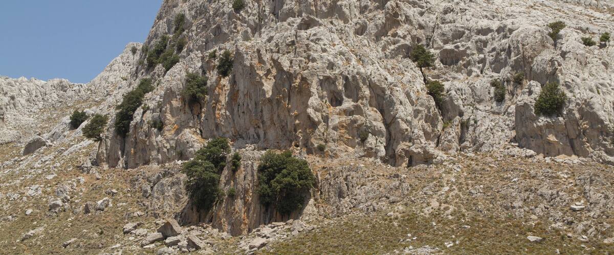 A rugged mountain with rocky terrain and sparse vegetation.