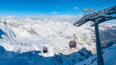 Ein mit Schnee bedeckter Berg mit Seilbahnen und blauem Himmel.