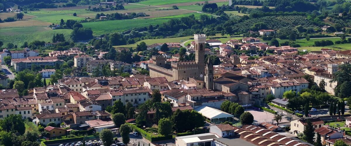 A historic town with a prominent castle, surrounded by lush green fields and rolling hills.