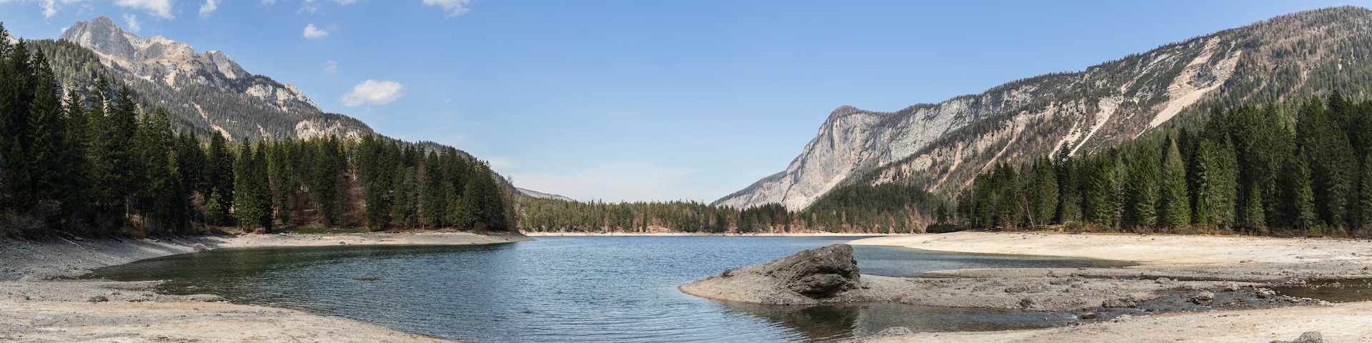 A lake surrounded by mountains and dense forests.