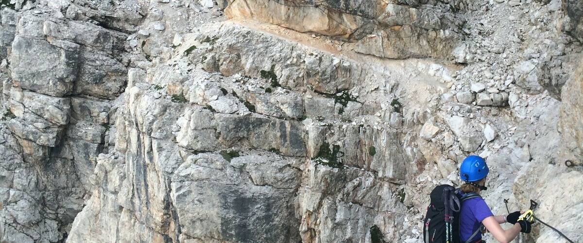 A hiker in a rocky canyon with steep cliffs.