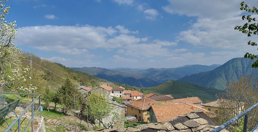 Un pueblo ubicado en un valle con casas escalonadas y montañas al fondo.