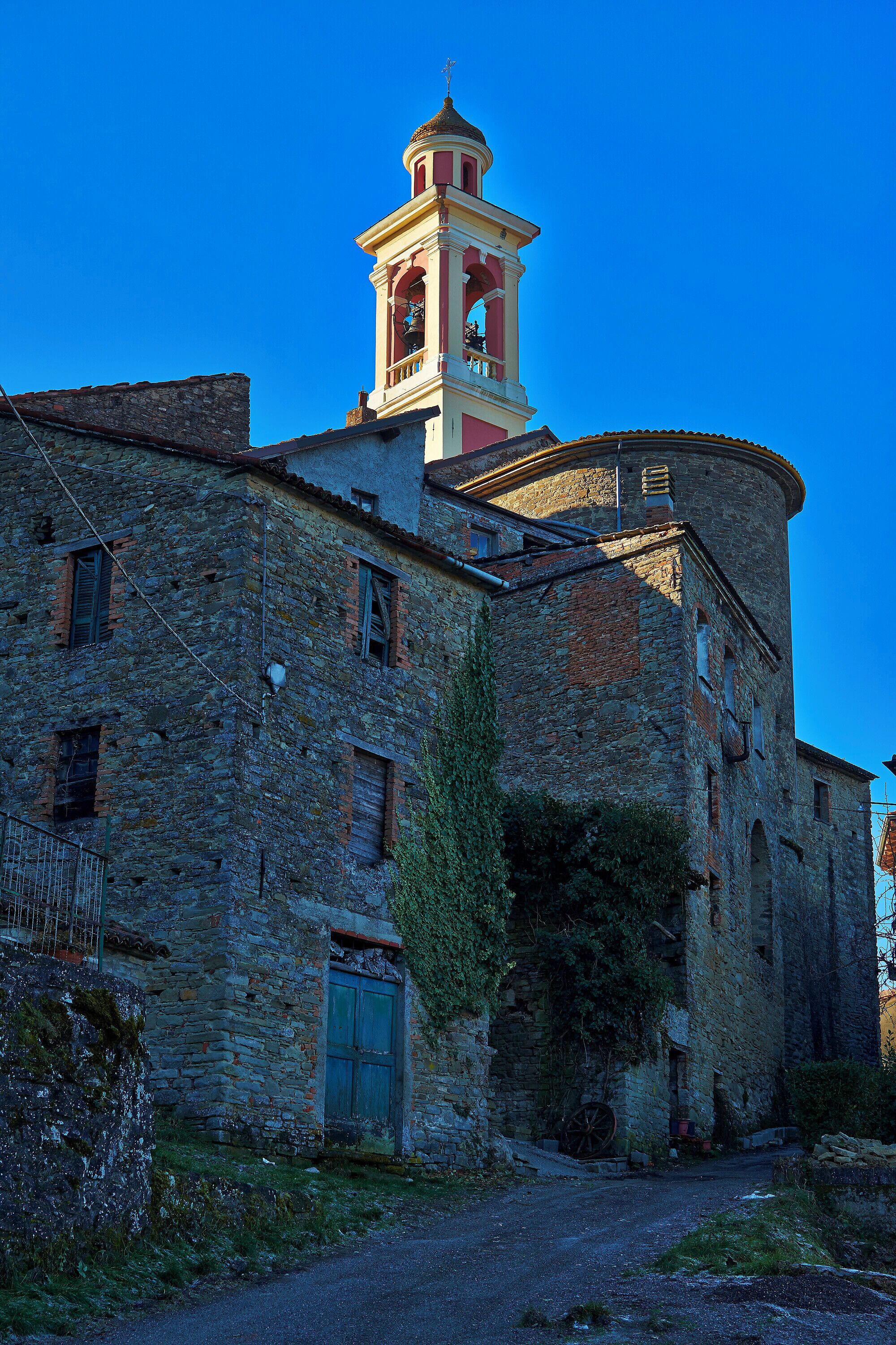 An old stone building with a bell tower and a circular structure.