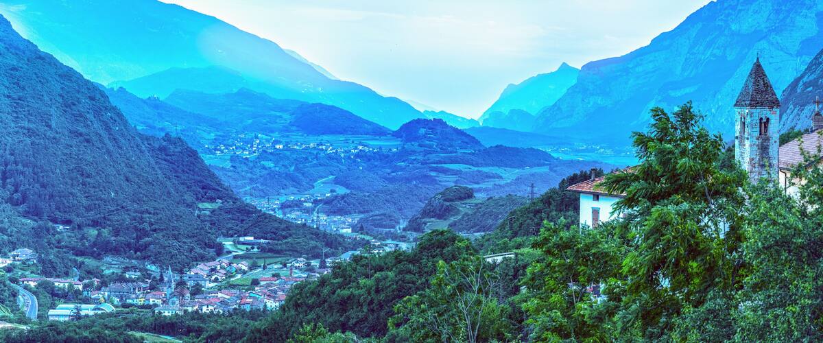 A mountainous landscape with a village, a church, and a church tower.