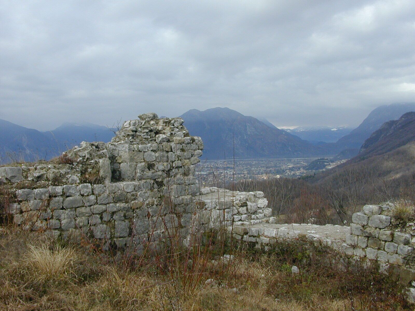 A stone ruin with a mountainous backdrop.