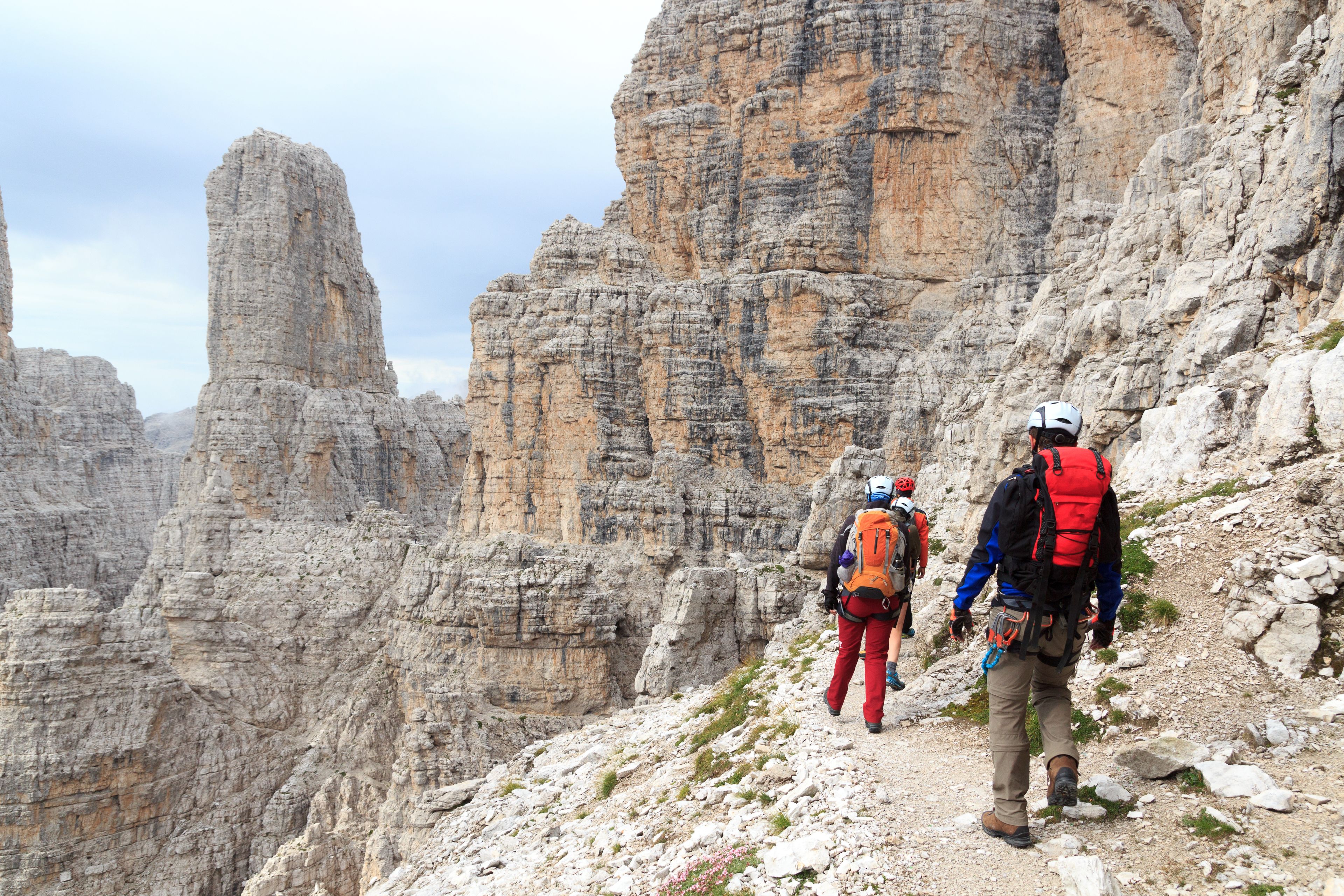 Un sendero pedregoso en la montaña con excursionistas.
