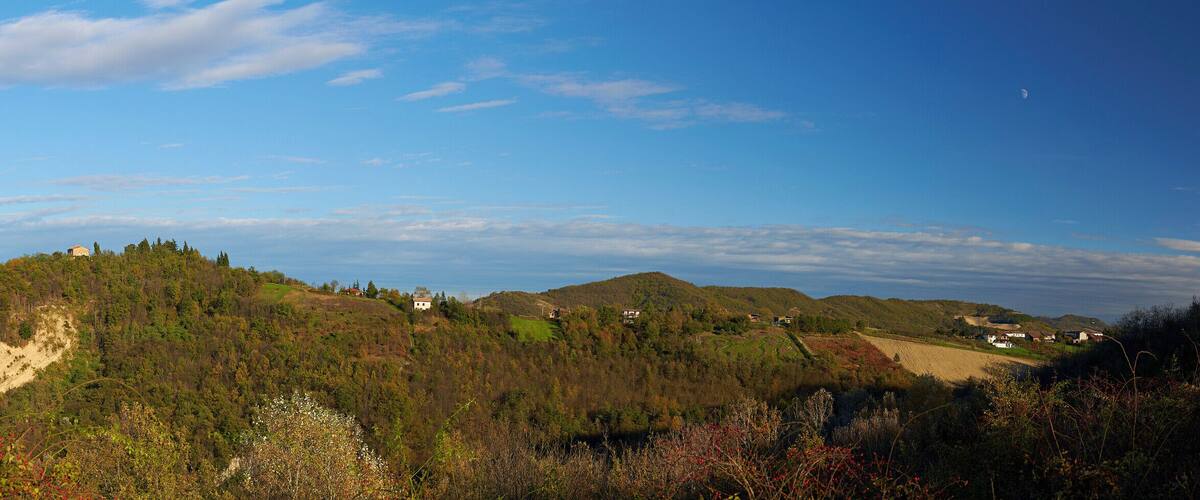 A mountainous landscape with scattered houses and a clear sky.