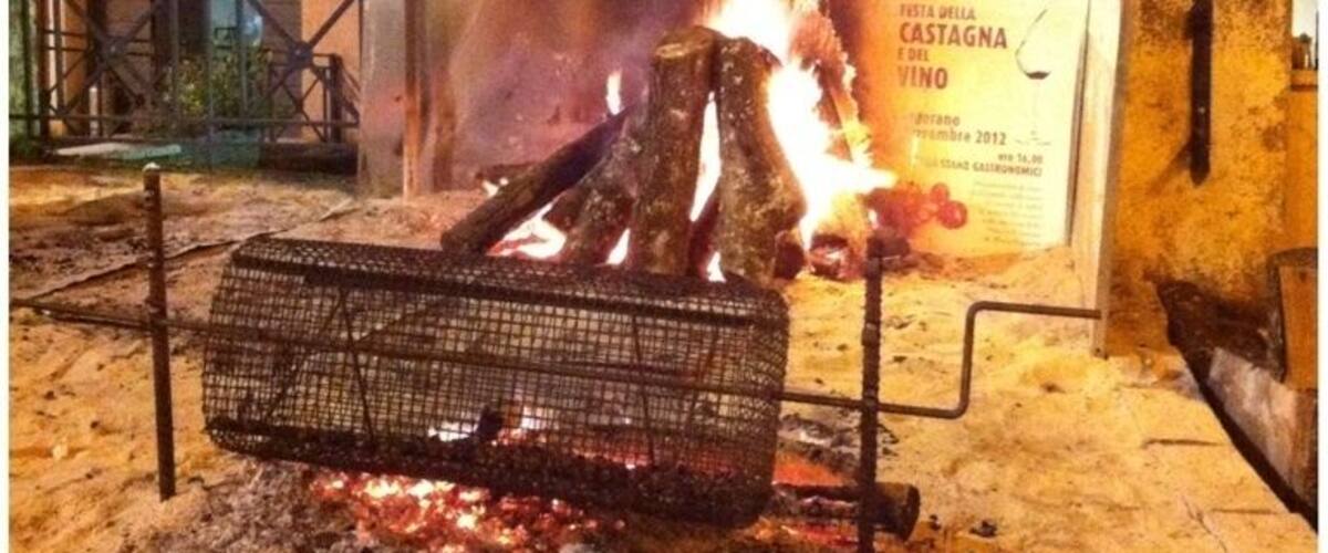 A fire burning in a metal container outdoors at night.