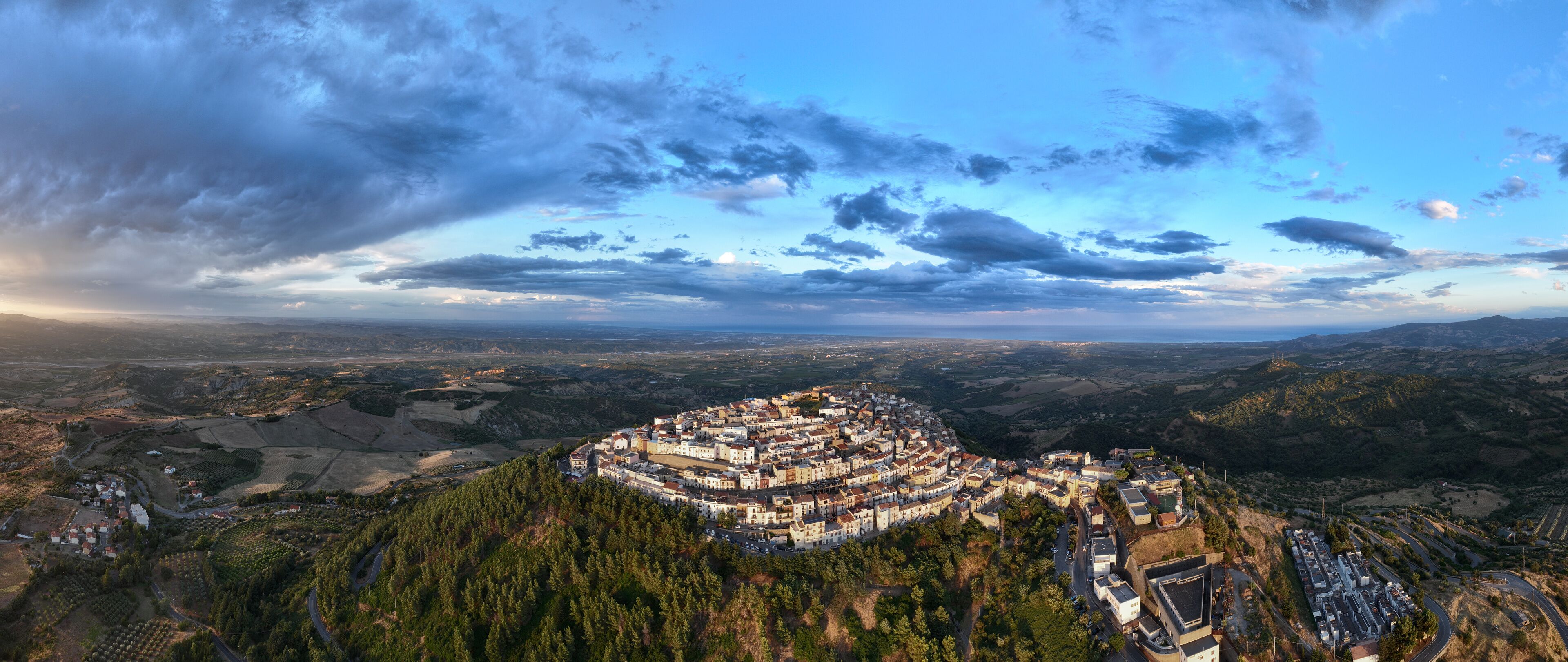 A mountainous town surrounded by forests and fields.