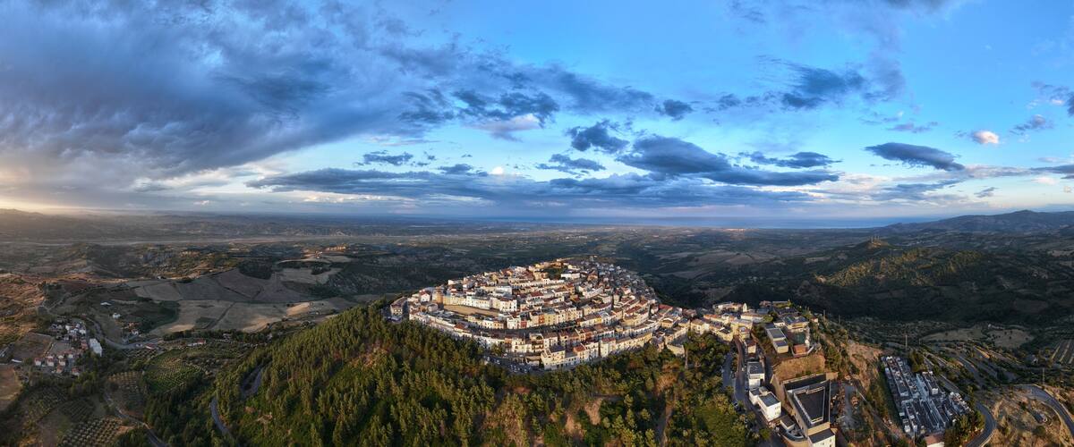 A mountainous town surrounded by forests and fields.