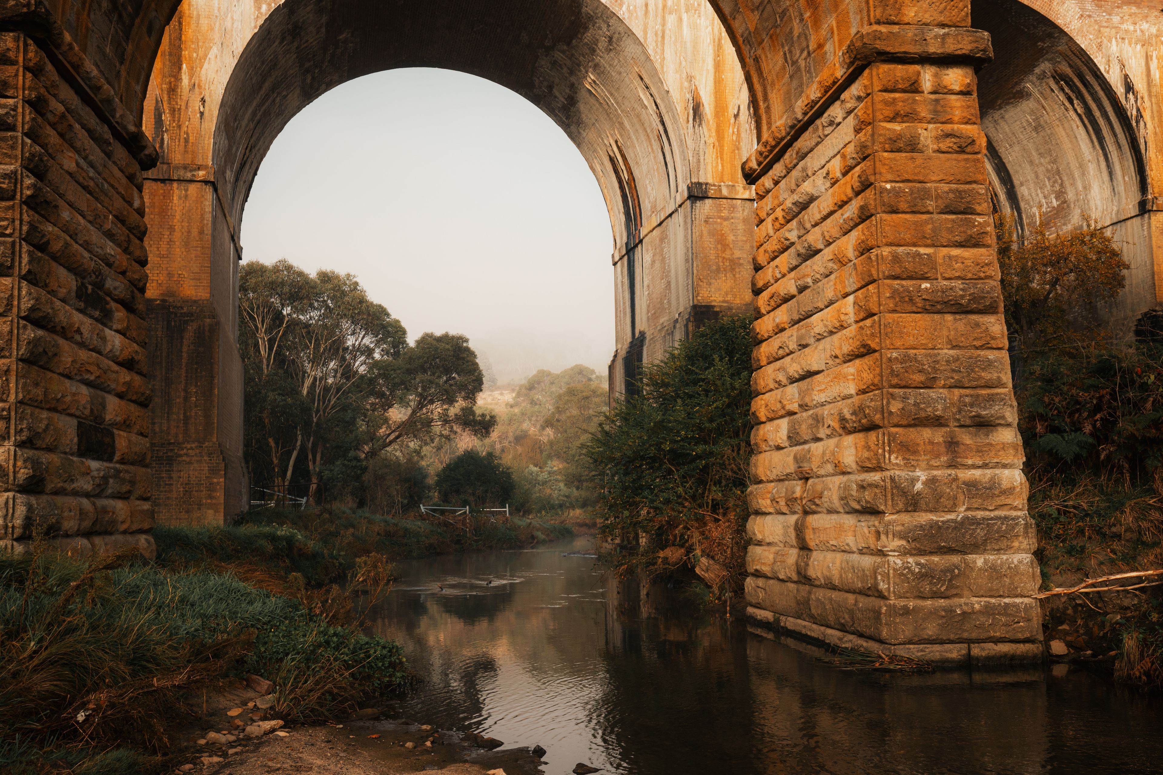 Archways of historic bridges over tranquil creek in the Blue Mountains