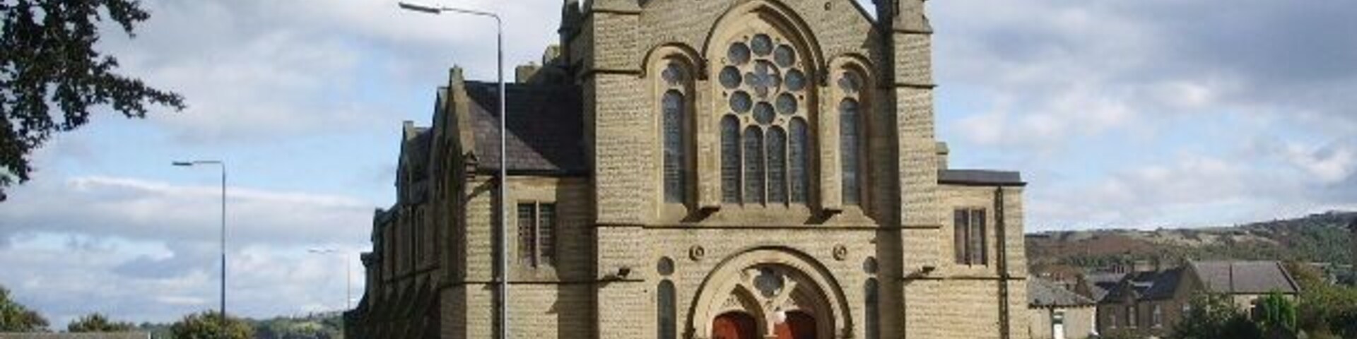 Una iglesia grande con un campanario destacado y ventanas de arco.