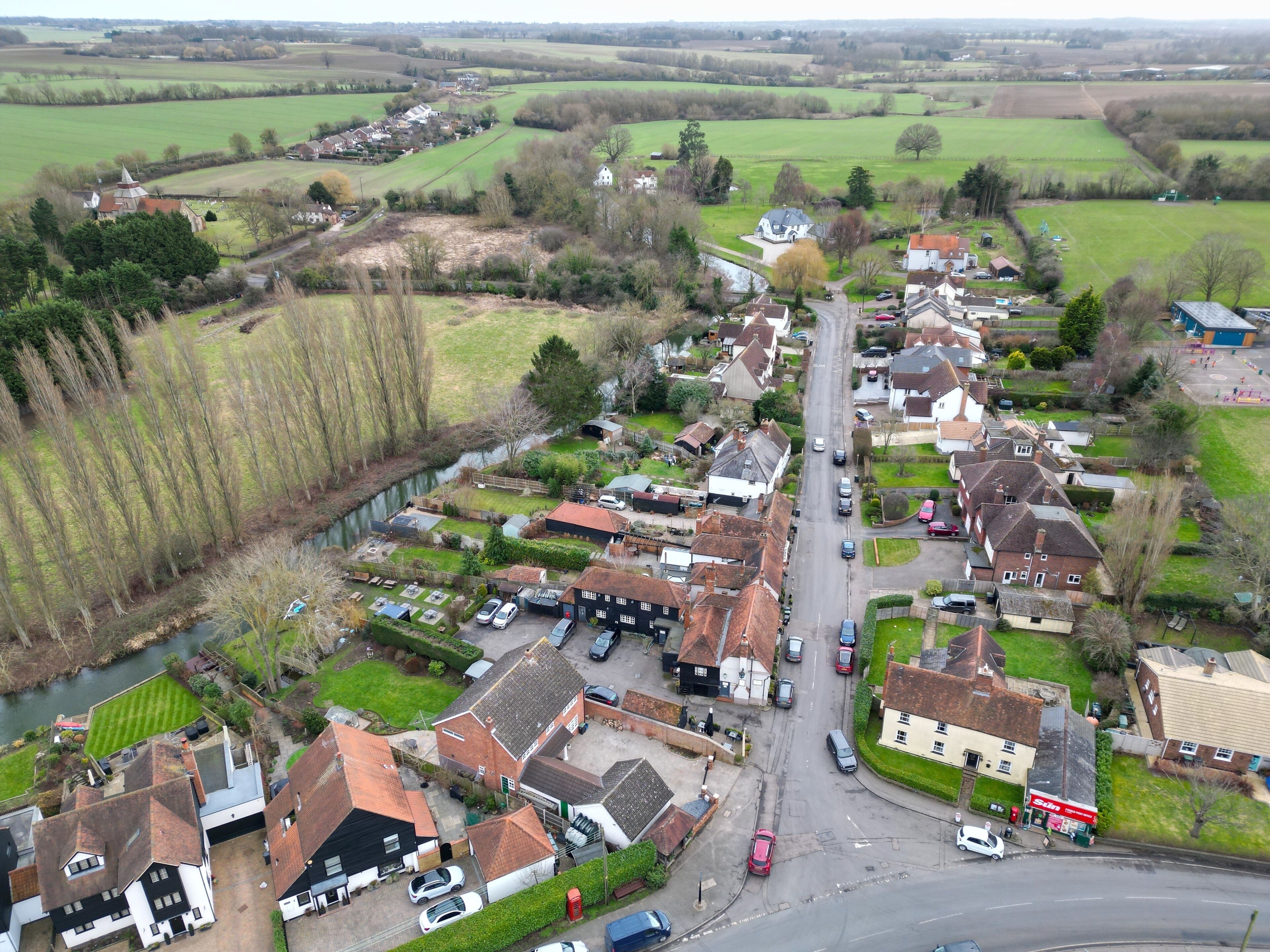 A village with a river, houses, and a church.